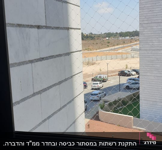 רשת נגד יונים מותקנת על חלון בניין